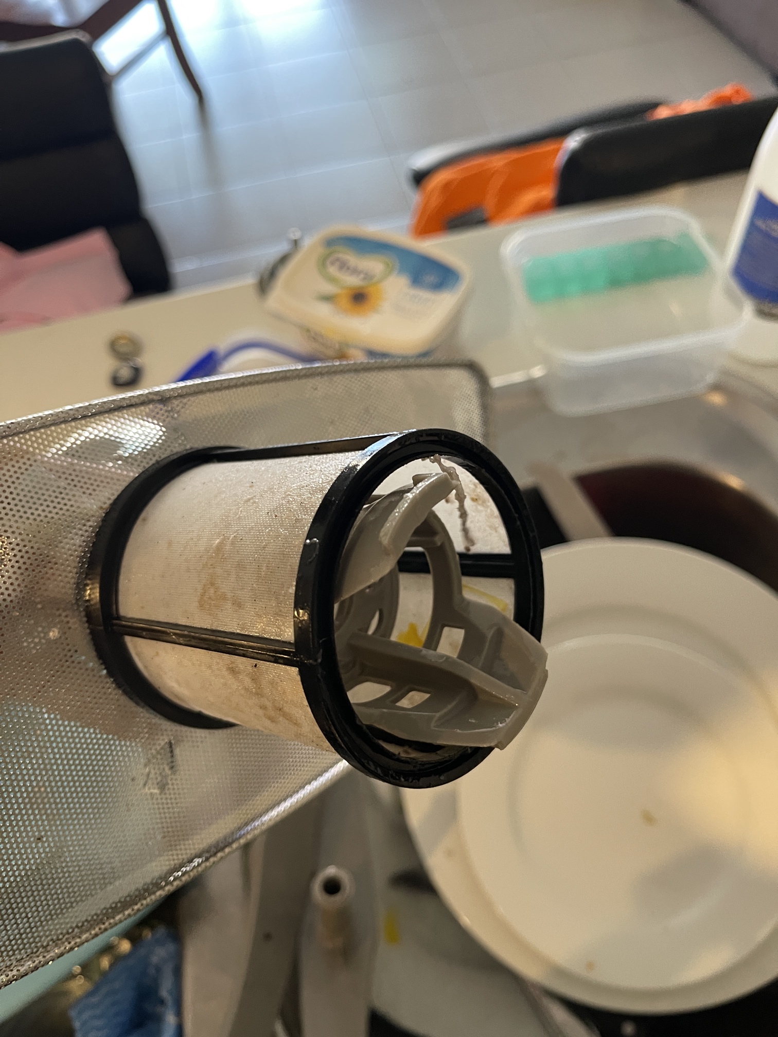 A second example of a dishwasher filter before cleaning, with severe build-up.