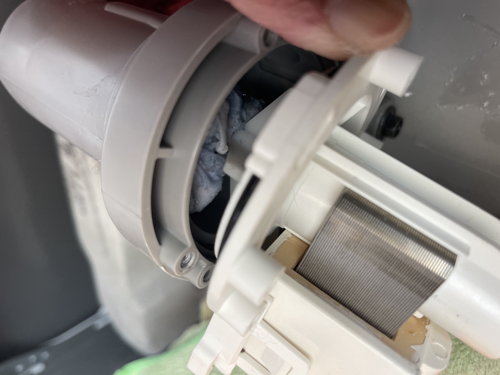 A blocked washing-machine drain being cleared by an Encore Service technician.